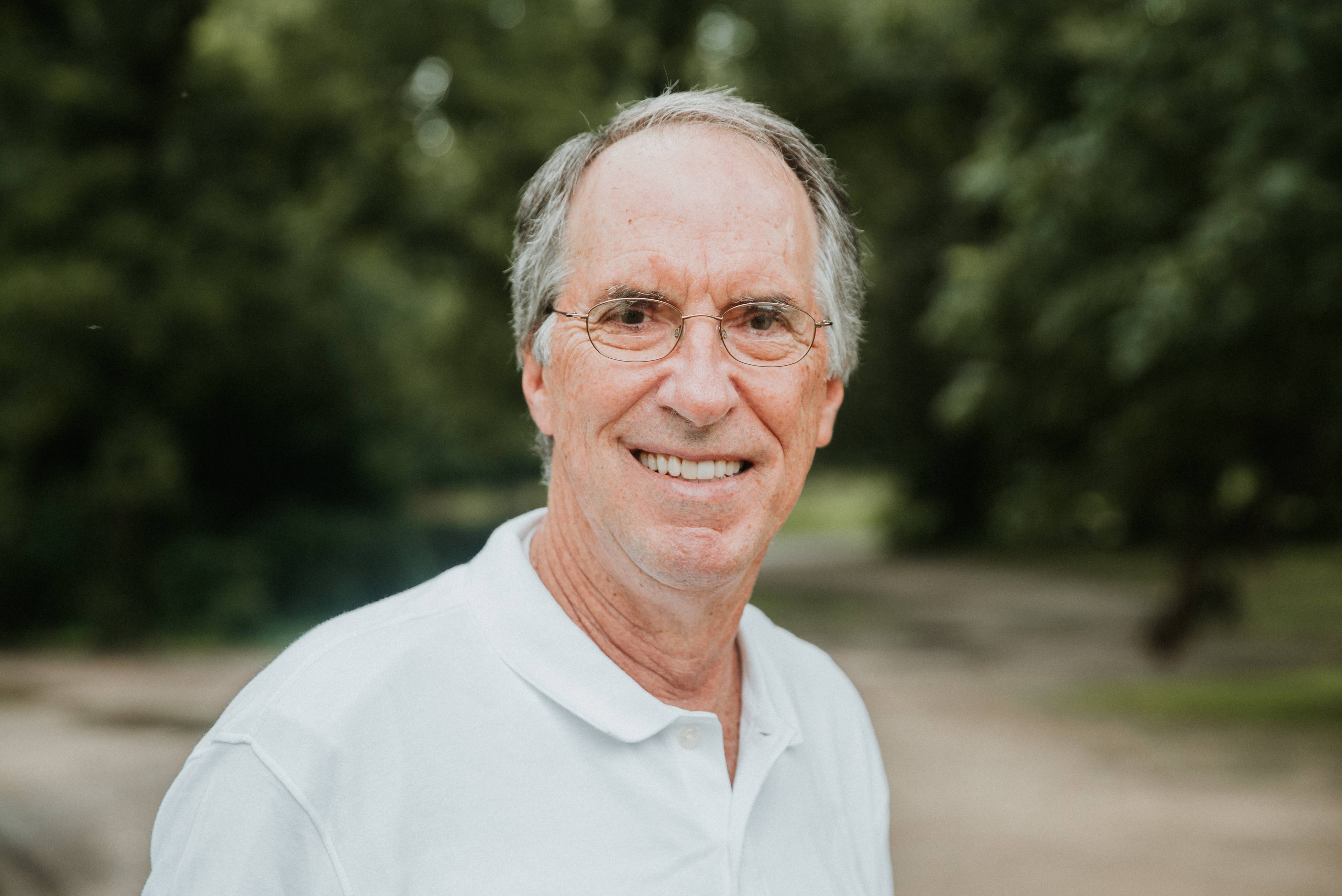 Larry Willson smiles for a portrait in the pecan groves.